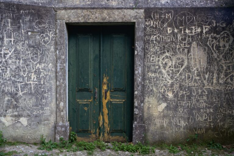 Graffiti covers the walls around a green door.