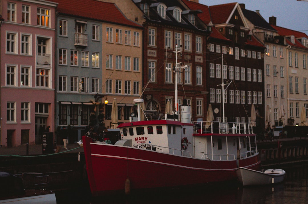 a red and white boat docked in a harbor